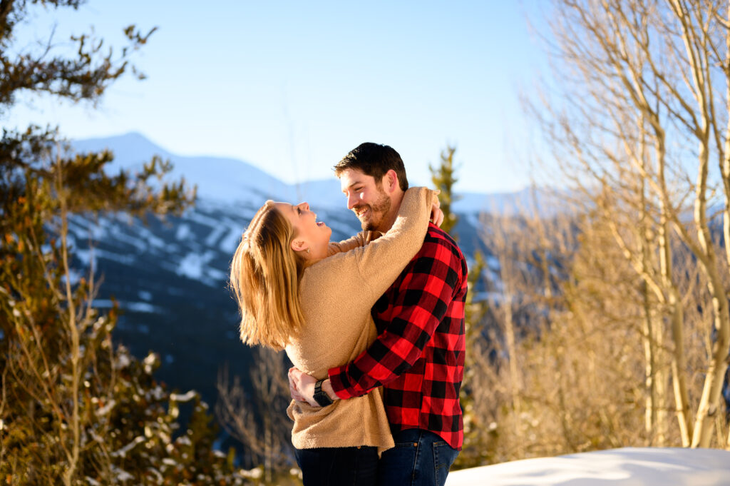 Couple laughing in front of snowy mountain