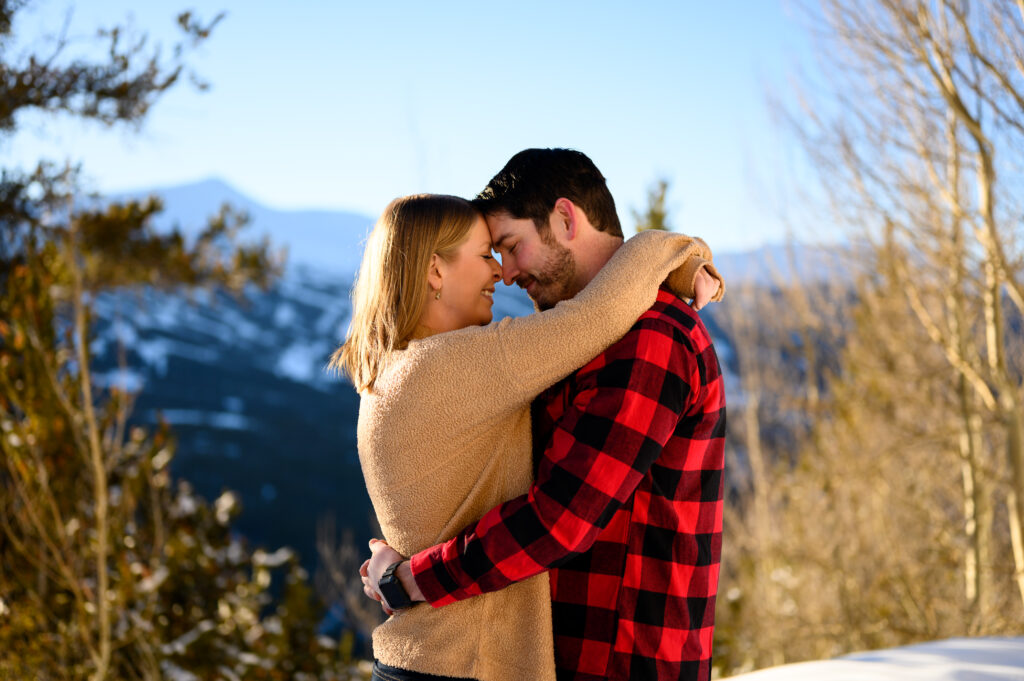 Couple hugging in front of snowy mountain